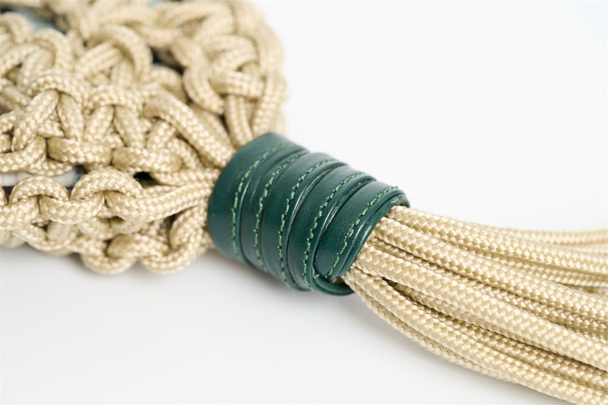Cordón de macramé anudado sobre cuero verde